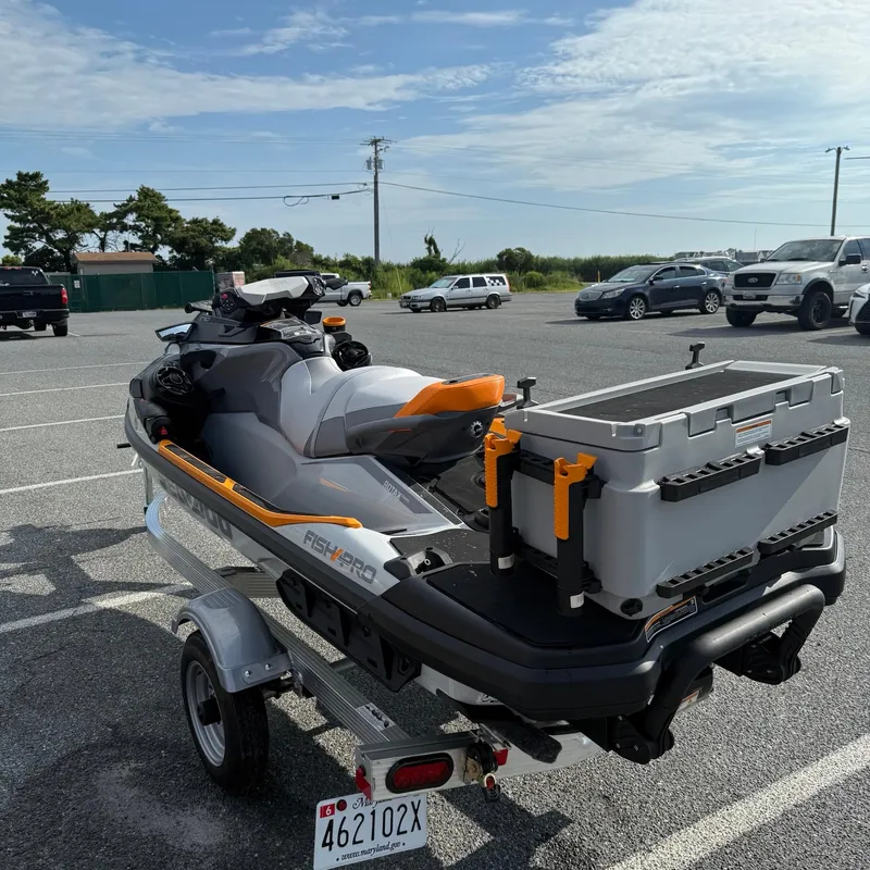 Slide: The Image of 2024 Sea-Doo Fishpro Trophy 170 on trailer in parking lot, equipped with storage box. - 6