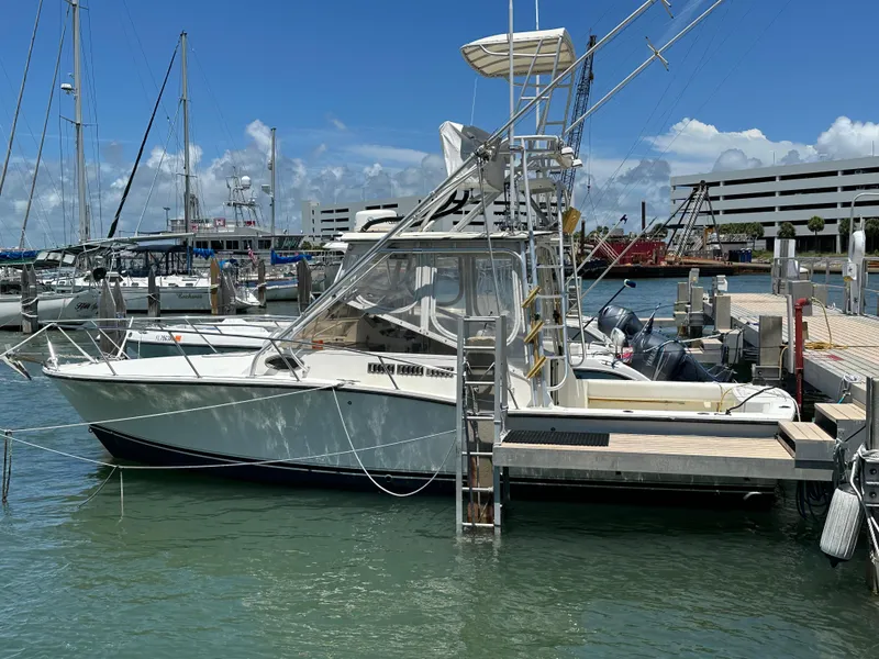 The Image of 2003 Carolina Classic 28 boat docked at marina under clear blue sky. - 1