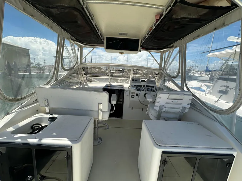 Slide: The Image of 2003 Carolina Classic 28 boat interior with helm, seating, and clear canopy. - 11