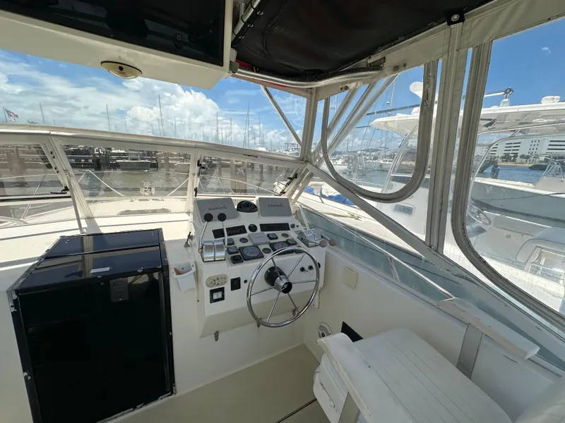 Slide: The Image of 2003 Carolina Classic 28 boat cockpit with steering wheel and navigation equipment. - 12