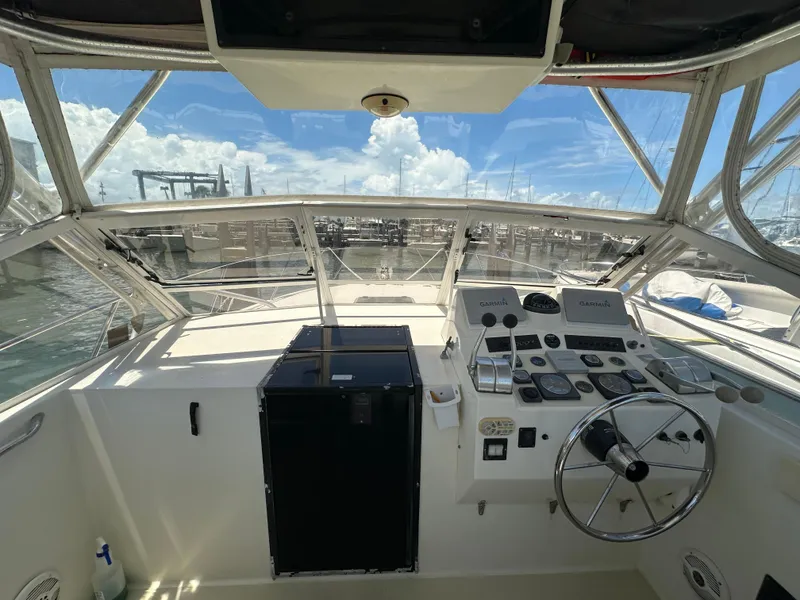 Slide: The Image of 2003 Carolina Classic 28 boat cockpit with steering wheel and navigation equipment. - 13