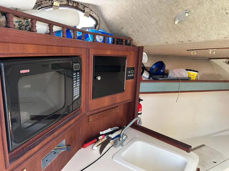 Slide: The Image of Interior of a 2003 Carolina Classic 28 boat with microwave and sink. - 24
