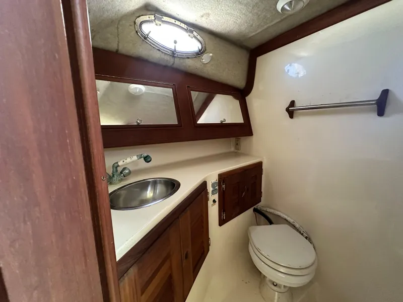 Slide: The Image of 2003 Carolina Classic 28 boat bathroom with sink, mirror, and toilet. - 26