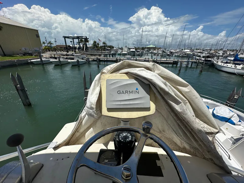 Slide: The Image of 2003 Carolina Classic 28 boat with Garmin navigation, docked at a marina under a cloudy sky. - 29