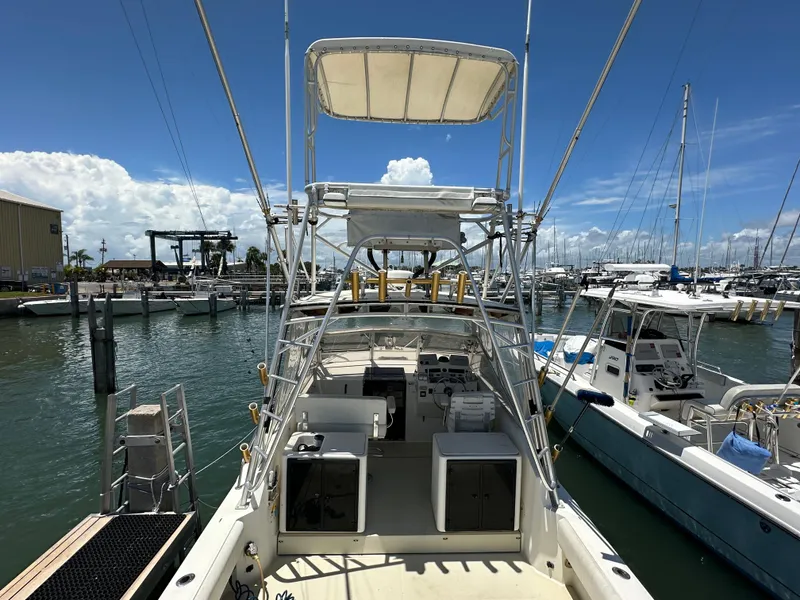Slide: The Image of 2003 Carolina Classic 28 boat docked at marina under clear blue sky. - 3