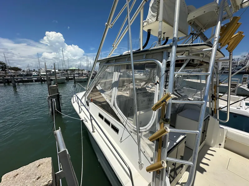 Slide: The Image of 2003 Carolina Classic 28 boat docked at marina under clear blue sky. - 4