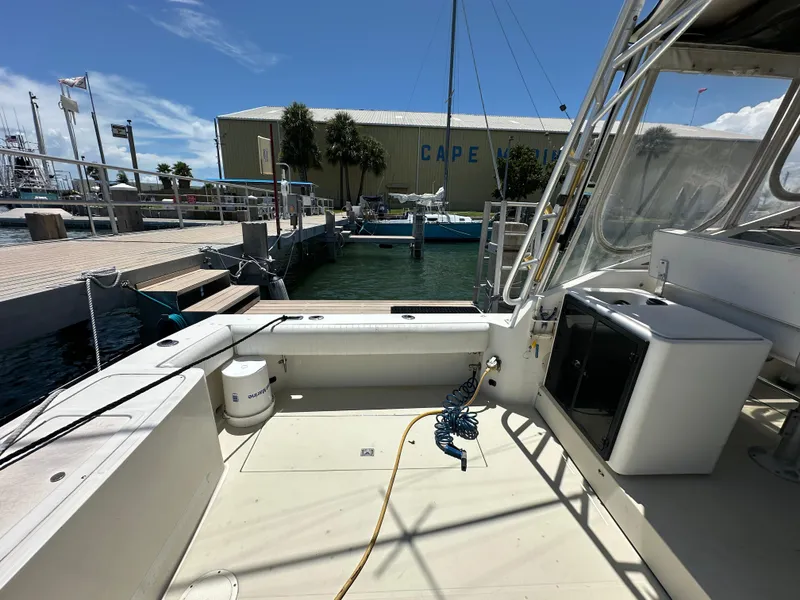 Slide: The Image of 2003 Carolina Classic 28 boat docked at marina, sunny day, clear sky, Cape Marina in background. - 6
