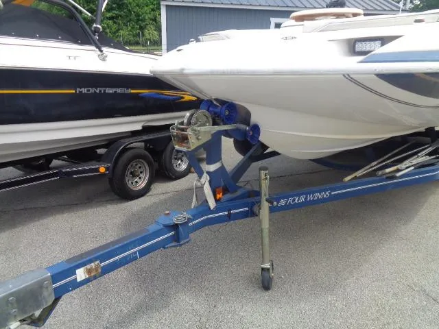 Slide: The Image of 1987 Sea Ray S23 boat on trailer, parked beside another boat, in outdoor setting. - 11