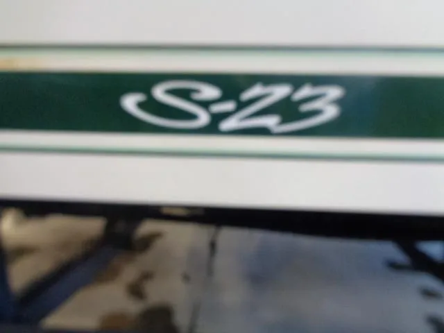 Slide: The Image of 1987 Sea Ray S23 boat model emblem with green and white design. - 4