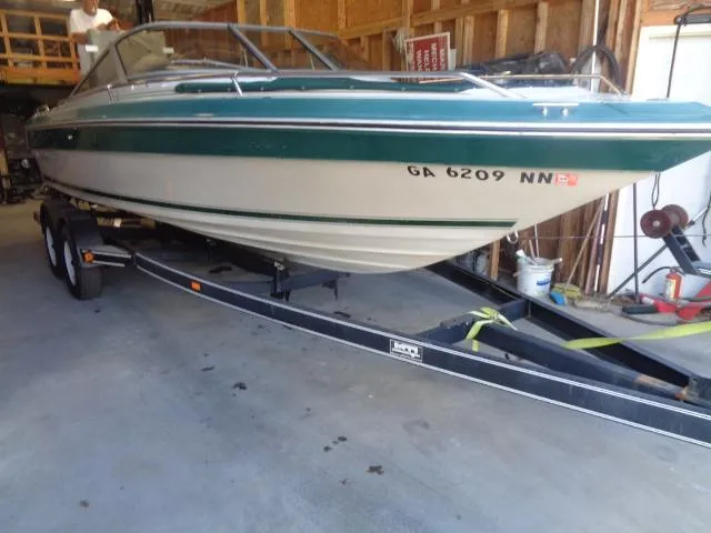 Slide: The Image of 1987 Sea Ray S23 boat on trailer in garage, green and white exterior. - 5