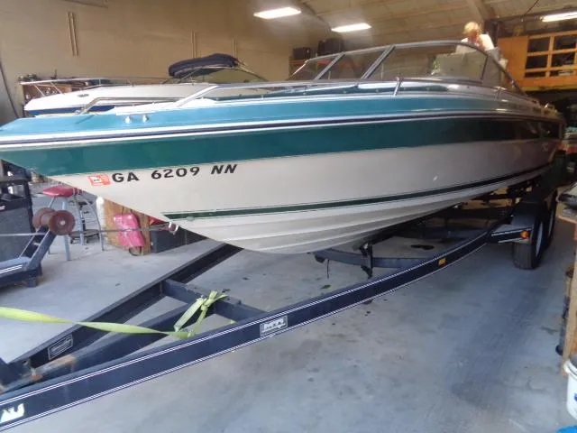 Slide: The Image of 1987 Sea Ray S23 boat on trailer in garage, green and white exterior. - 6