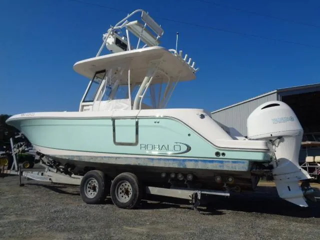 Slide: The Image of 2019 Robalo R272 Center Console boat on trailer, light blue hull, outdoor setting. - 11