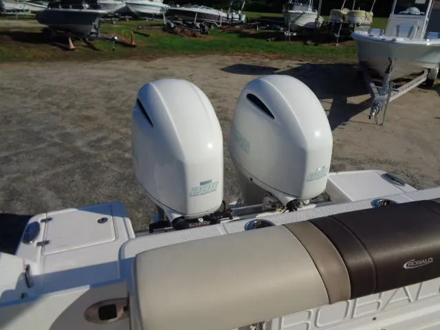 Slide: The Image of 2019 Robalo R272 Center Console with twin outboard engines in a boatyard setting. - 18