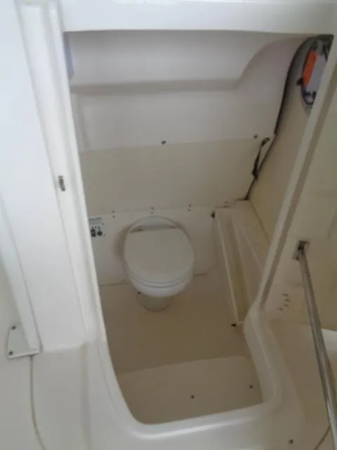 Slide: The Image of 2019 Robalo R272 Center Console boat interior with compact marine toilet. - 31