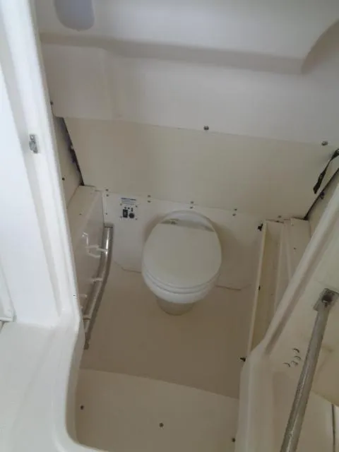 Slide: The Image of 2019 Robalo R272 Center Console boat interior with compact marine toilet. - 32