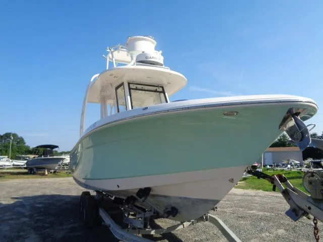 Slide: The Image of 2019 Robalo R272 Center Console boat on trailer under clear blue sky. - 4