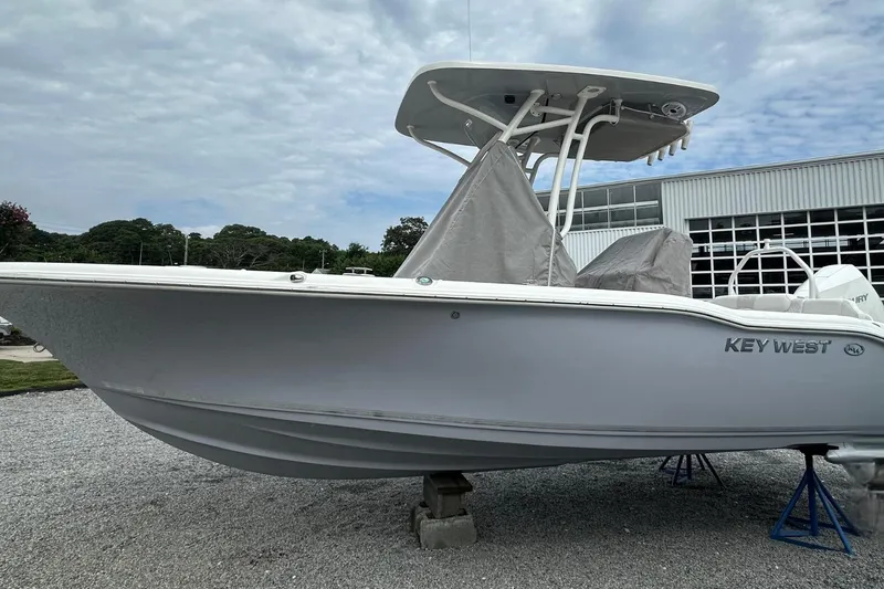 Slide: The Image of 2026 Key West 219 FS boat on display, covered and elevated, with a cloudy sky backdrop. - 1