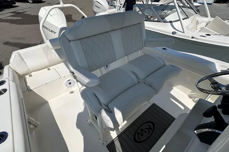 Slide: The Image of 2026 Key West 219 FS boat interior with white seating and steering wheel. - 13
