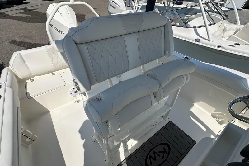 Slide: The Image of 2026 Key West 219 FS boat interior with white seating and steering wheel. - 14