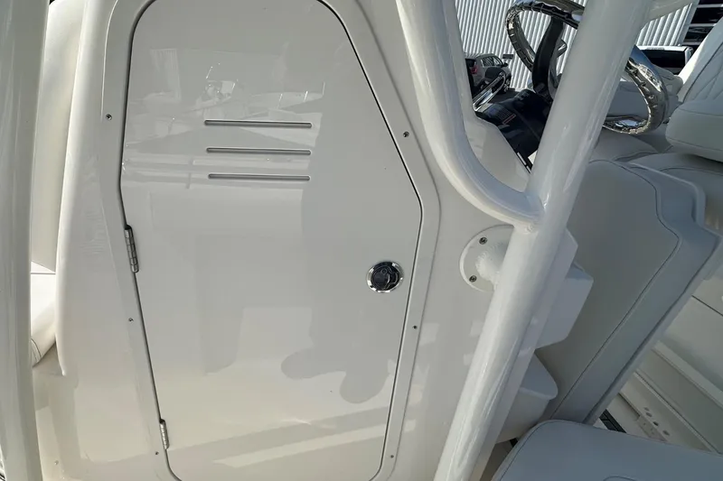 Slide: The Image of 2026 Key West 219 FS boat interior, featuring a sleek white console and steering area. - 18