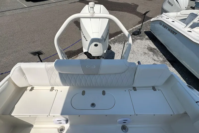 Slide: The Image of 2026 Key West 219 FS boat interior with white seating and Mercury engine. - 8