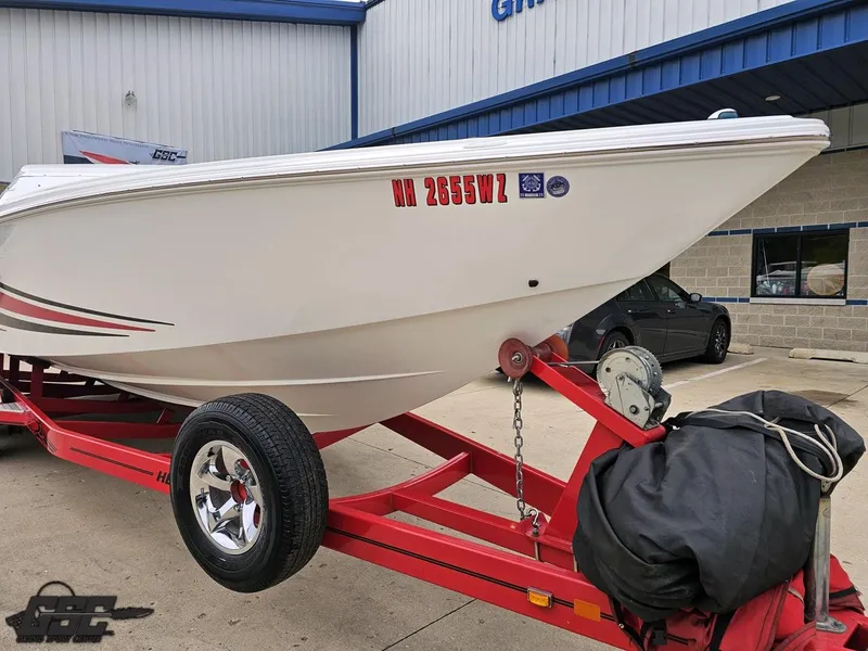 Slide: The Image of 2005 Baja 25 Outlaw boat on red trailer, parked outside a building. - 14