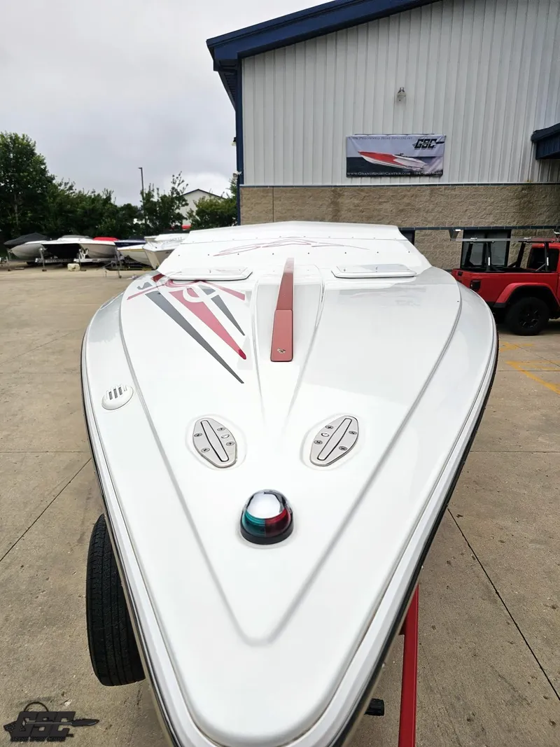 Slide: The Image of 2005 Baja 25 Outlaw boat on trailer, parked outside a building. - 15