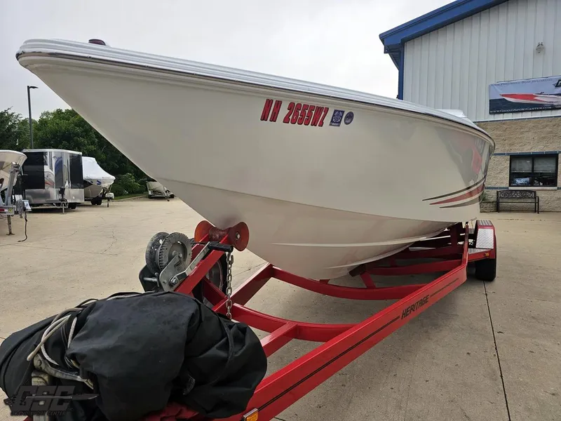 Slide: The Image of 2005 Baja 25 Outlaw boat on red trailer outside a building. - 18