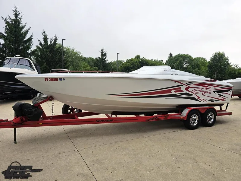 Slide: The Image of 2005 Baja 25 Outlaw speedboat on red trailer, parked outdoors. - 20