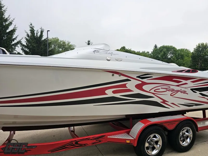 Slide: The Image of 2005 Baja 25 Outlaw speedboat with red and black graphics on a trailer. - 23