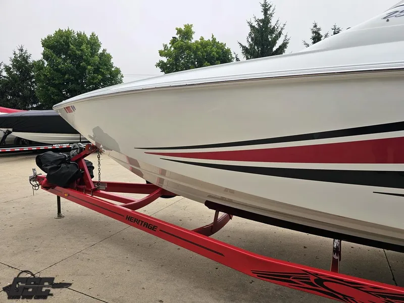 Slide: The Image of 2005 Baja 25 Outlaw boat on red trailer, sleek design with red and black accents. - 26