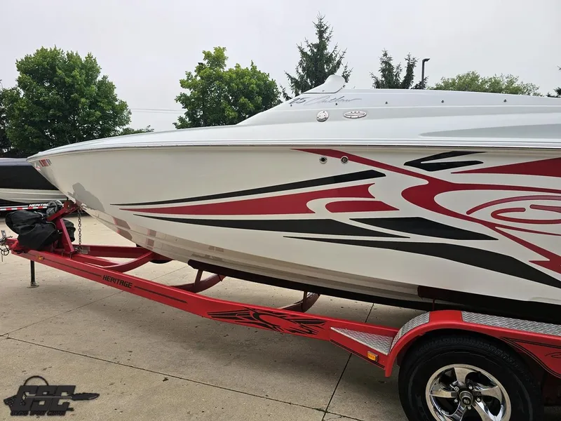 Slide: The Image of 2005 Baja 25 Outlaw speedboat on red trailer with bold graphics. - 27