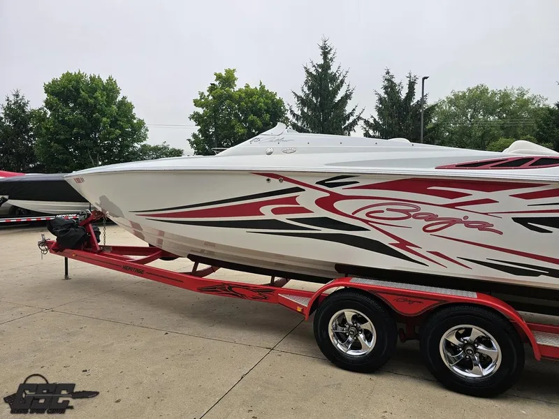 Slide: The Image of 2005 Baja 25 Outlaw speedboat on a red trailer, featuring sleek graphics and vibrant design. - 28