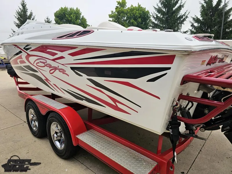 Slide: The Image of 2005 Baja 25 Outlaw boat with red and black graphics on a red trailer. - 31
