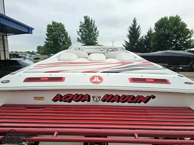 Slide: The Image of 2005 Baja 25 Outlaw speedboat with "Aqua Haulin'" decal, parked outdoors. - 38