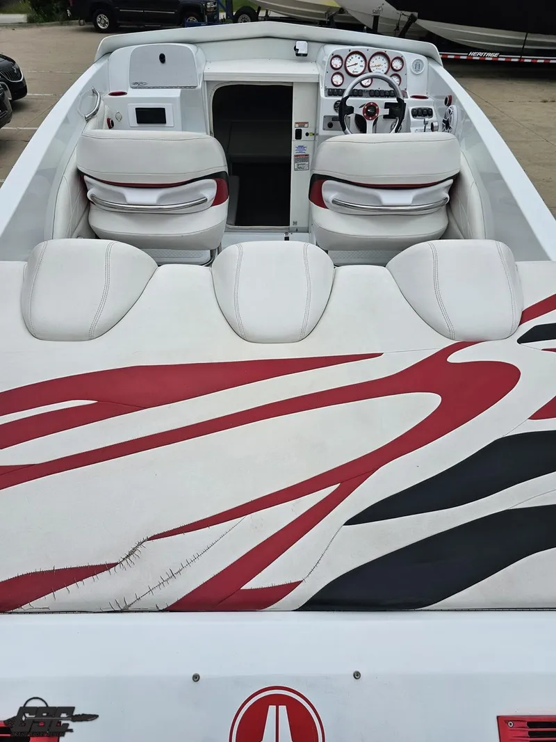 Slide: The Image of 2005 Baja 25 Outlaw boat interior with red and white seating and dashboard. - 42