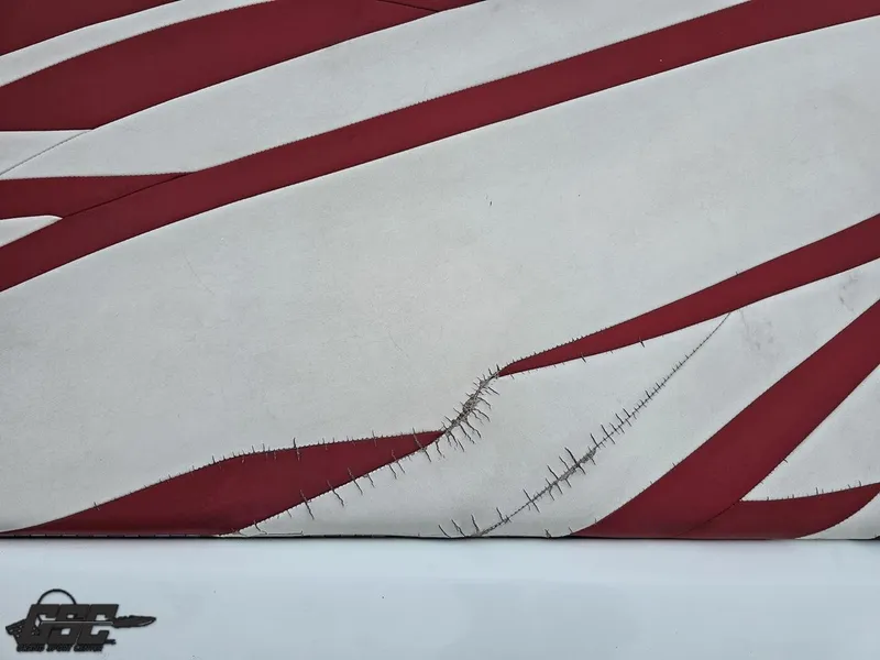 Slide: The Image of 2005 Baja 25 Outlaw boat upholstery with red and white stripes, showing visible wear and stitching. - 45