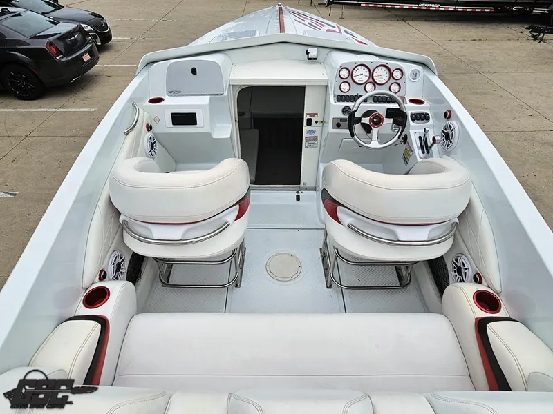 Slide: The Image of 2005 Baja 25 Outlaw boat interior with white seating and modern dashboard controls. - 46