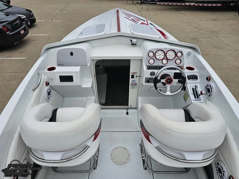 Slide: The Image of 2005 Baja 25 Outlaw boat interior with white seating and control panel. - 48