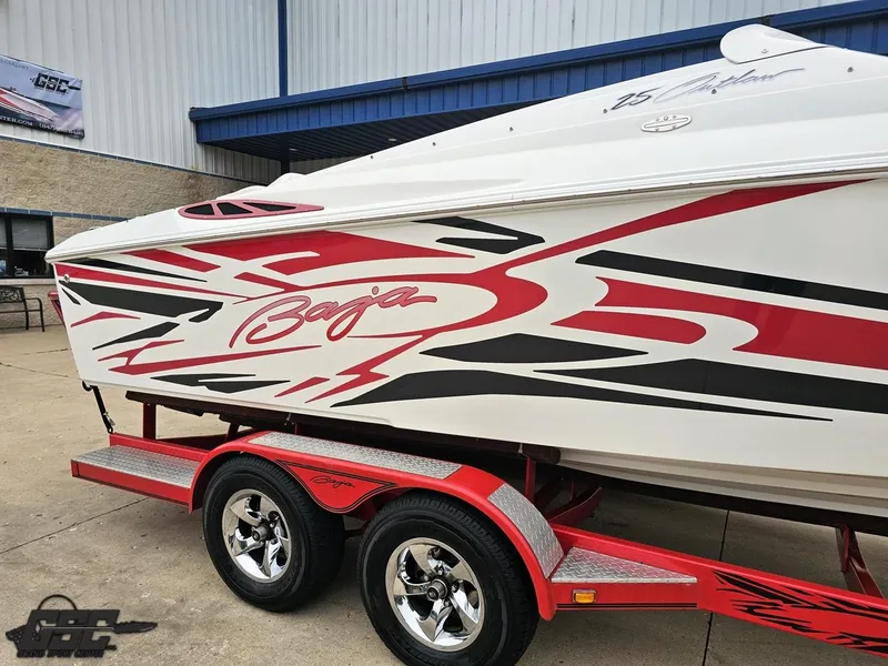 Slide: The Image of 2005 Baja 25 Outlaw boat with red and black graphics on a matching trailer. - 5
