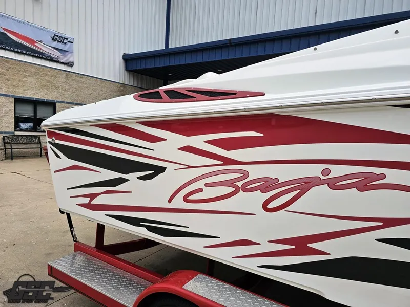 Slide: The Image of 2005 Baja 25 Outlaw boat with red and black graphics on a trailer. - 6