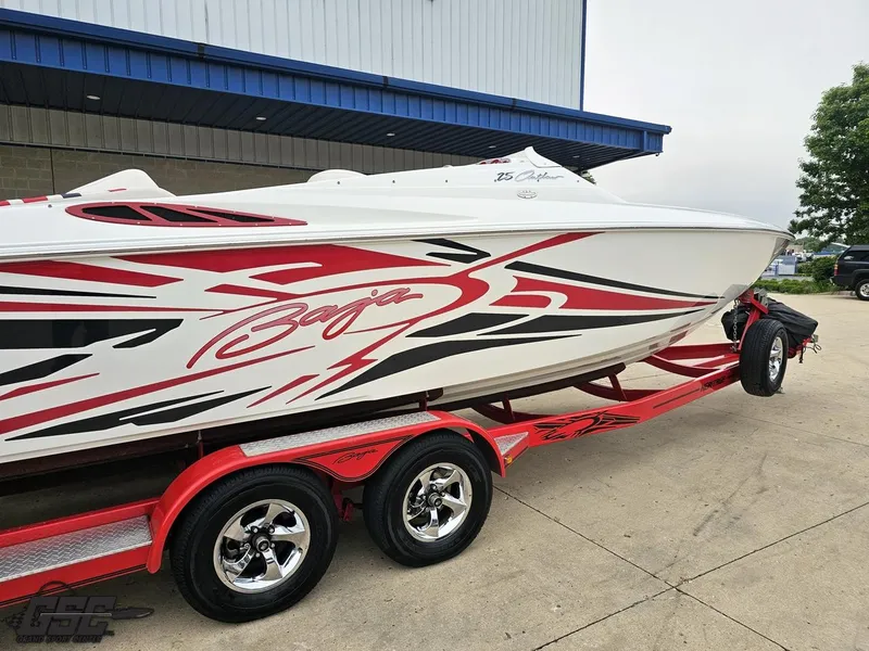 Slide: The Image of 2005 Baja 25 Outlaw speedboat with red and black graphics on a trailer. - 9