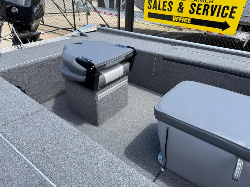 Slide: The Image of 2018 Lowe Stryker 16 boat interior with gray seating and sales sign in background. - 16