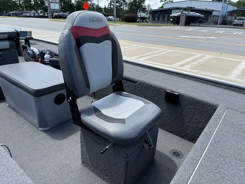 Slide: The Image of 2018 Lowe Stryker 16 boat seat, gray and red, on a carpeted deck. - 18