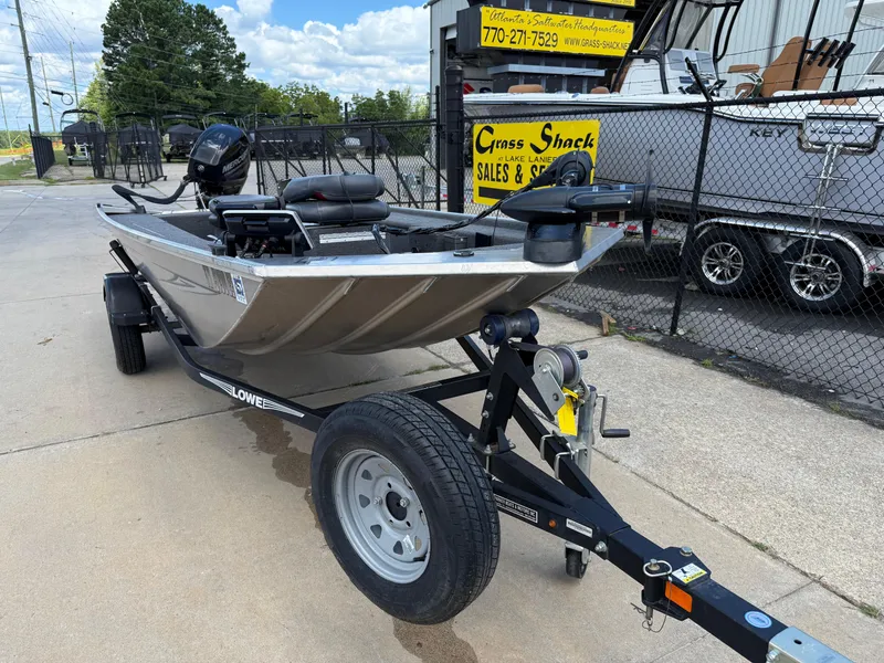 Slide: The Image of 2018 Lowe Stryker 16 boat on trailer, parked outside dealership. - 2