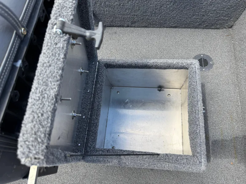 Slide: The Image of Open storage compartment in 2018 Lowe Stryker 16 boat, featuring carpeted interior and metal lining. - 23
