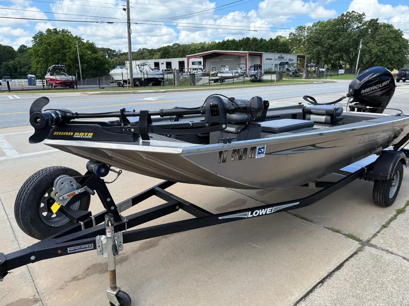 Slide: The Image of 2018 Lowe Stryker 16 boat on trailer with Minn Kota motor, parked outdoors. - 27