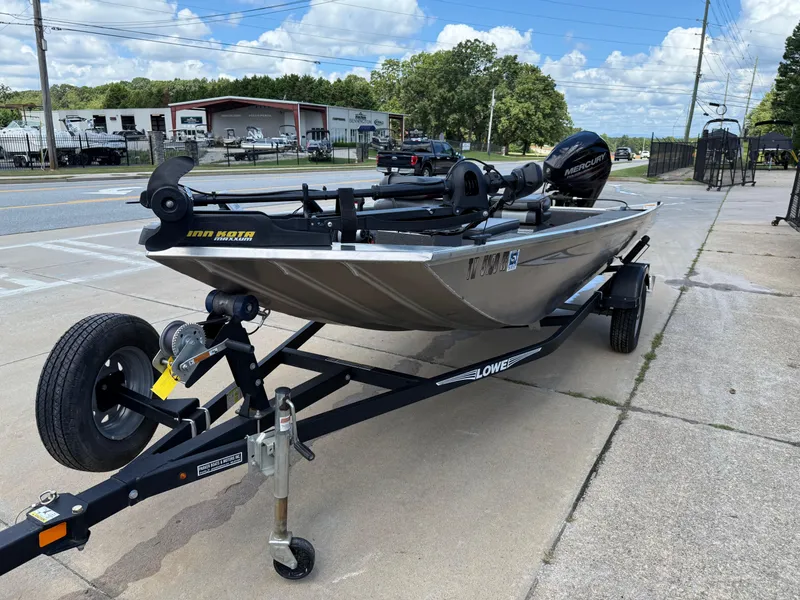 Slide: The Image of 2018 Lowe Stryker 16 boat on trailer, parked outdoors, featuring Minn Kota motor. - 3