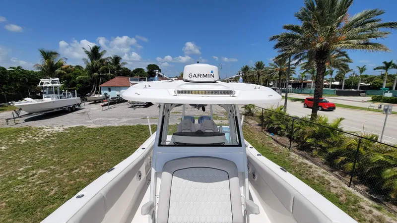 Slide: The Image of 2024 Sea Fox 288 Commander boat with Garmin equipment, parked near palm trees and a red car. - 14