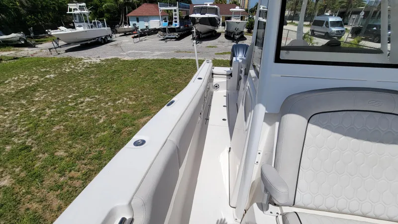 Slide: The Image of 2024 Sea Fox 288 Commander boat, side view, parked outdoors with other boats nearby. - 15